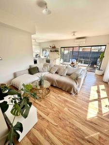 a living room with a couch and a table at Melbourne home close to Airport & Train Station in Melbourne