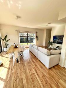 a living room with a couch and a table at Melbourne home close to Airport & Train Station in Melbourne