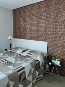 a bedroom with a bed and a brick wall at Manawa Beach Flat - Porto de Galinhas in Porto De Galinhas