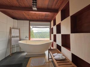 a large bath tub in a bathroom with a window at True Bali Villa in Blimbing