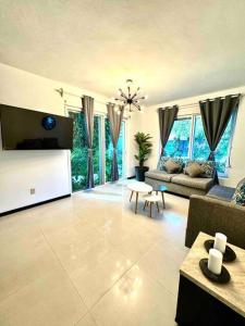 a living room with a couch and a table at 5th AVENUE oasis 8 personas in Playa del Carmen