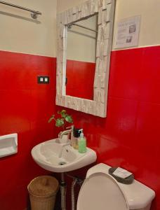 a red bathroom with a toilet and a sink at Hidden of Cailan Extension Transient House in El Nido +47 photos