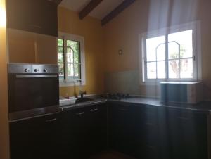 una cucina con fornelli, lavello e finestra di Zoranj Delair a Sainte-Anne