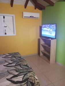 una camera da letto con un letto e una TV a schermo piatto di Zoranj Delair a Sainte-Anne