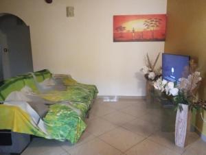 una camera da letto con un letto e una TV a schermo piatto di Zoranj Delair a Sainte-Anne