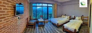 Un dormitorio con dos camas y una pared de ladrillo. en Hotel Dhulikhel View Point, en Dhulikhel
