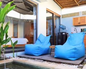 a room with a bed and blue pillows next to a pool at Peacock Private Pool Villa, self check-in, Workspace, Kitchen in Dalung