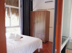 una camera da letto con un letto con lenzuola bianche e una finestra di Resort Thái An a Cai Be Altre 15 foto