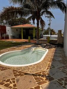 a small pool in a yard with a palm tree at ¨Departamentos Vista Real¨ in Chachalacas