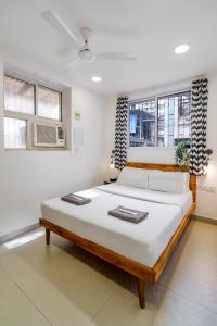 a bedroom with a large bed in a room with windows at Alcove 1BHK Bandra W by The Bombay Home Company in Mumbai