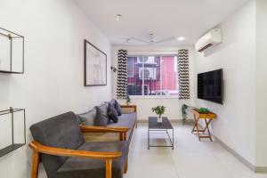 a living room with a couch and a table at Alcove 1BHK Bandra W by The Bombay Home Company in Mumbai +14 photos