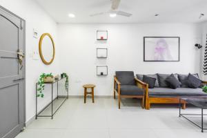 a living room with a couch and a chair at Alcove 1BHK Bandra W by The Bombay Home Company in Mumbai
