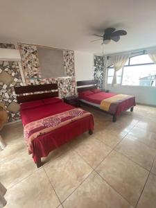 a bedroom with two beds and a ceiling fan at ¨Departamentos Vista Real¨ in Chachalacas