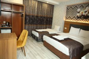 ヴァンにあるBianca Hotel VANのベッド2台と机があるホテルの部屋