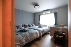 a bedroom with a bed with two cats laying on it at The Villa Seaside in Abashiri +126 photos