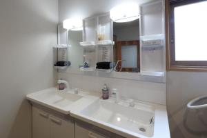 um banheiro branco com uma pia e um espelho em The Villa Seaside em Abashiri