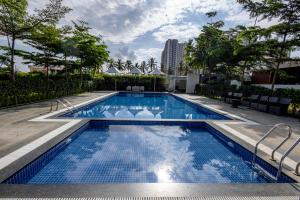 a swimming pool with blue water in a building at Veerdency Luxury Resort - 3 Km to Banglore Airport in Bangalore