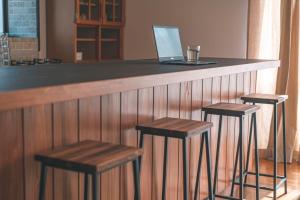 a bar with two stools and a laptop on a counter at 懐-KAI- in Kawazu