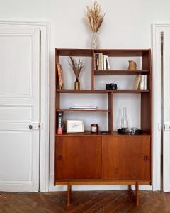 a wooden book shelf in a room at La Maison des Ifs Terracotta in Mamers