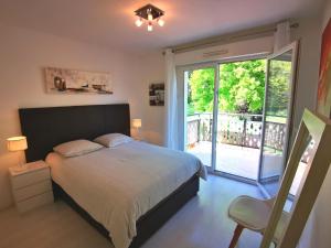 a bedroom with a bed and a sliding glass door at Appartement 90 m2 avec parking terrasse balcons, proche du port et plages in Arcachon