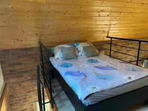 a bed in a room with a wooden wall at U Marty - Agroturystyka in Rogawka