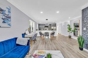 a living room and dining room with a blue couch at Charlotte Spacious Home in Charlotte +30 photos