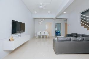 a living room with a couch and a flat screen tv at kings pine residences homestay kundasang ranau 15 in Ranau