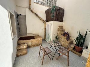 a room with two chairs and a table and some plants at L'isola in Augusta