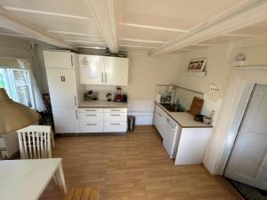 a kitchen with white appliances and a wooden floor at Mandauhaus Großschönau in Großschönau