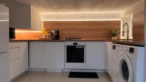 a kitchen with a washer and dryer in it at Appartement Love in Bussières-lès-Belmont