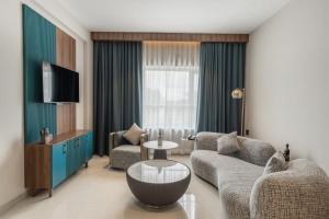 a living room with a couch and a table and a tv at VSC Porto Marina in Bālarāmpuram