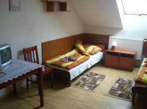 a small room with a bed and a table and a tv at Zajazd Pułaskiego in Konstancin-Jeziorna