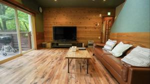 a living room with a couch and a tv at clover house in Nasu