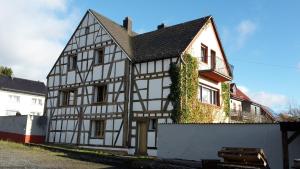 um velho edifício branco e preto com hera em Historische Wassermühle em Birgel