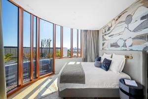 a bedroom with a large bed and large windows at Forbes Manaa Living in Perth