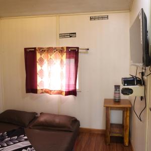 a living room with a couch and a window at Farmers Son CampingGround in Sakleshpur