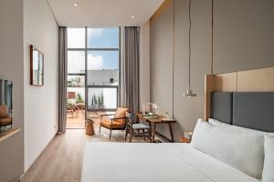 une chambre d'hôtel avec un lit, une table et des chaises dans l'établissement Wuyu Hotel - Chongqing Liangjiang Happiness Plaza & Xingfu Square & GuangdianYuan metro, à Chongqing