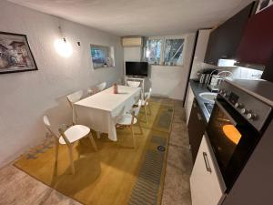 a kitchen and dining room with a white table and chairs at The Cozy House in Kyustendil