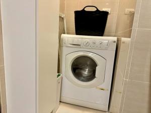 a washing machine with a bag on top of it at BGC 1BR unit linked to Uptown Mall with own parking in Manila