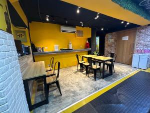 a restaurant with tables and chairs and a yellow wall at Taipei Inn in Taipei