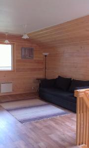 a living room with a couch in a wooden room at Rautjärvi Cottage in Kokkola