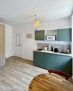 cocina con armarios azules y mesa en Une touche de vert, en Mulhouse