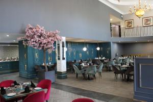 a dining room with tables and chairs and a tree at Happy Valley Hotel and Casino in Ezulwini