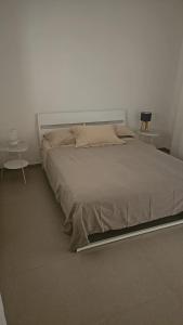 a large bed in a white room with two tables at I due Ulivi Cornino in Custonaci +37 photos