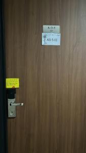 een houten deur met een bord erop bij Yenbear Homestay Kozi Square Kuching Sarawak in Kuching