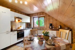 a kitchen with a wooden ceiling and a table with flowers at Ferienwohnung Schank in Sauldorf
