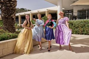 four women in dresses posing for a picture at Blue Sea Beach Resort in Faliraki