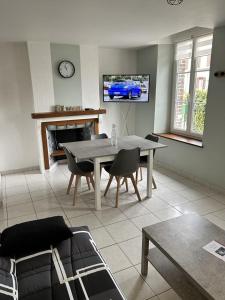 a living room with a table and a tv at Appartement 29A - MAILLY LE CAMP in Mailly-le-Camp