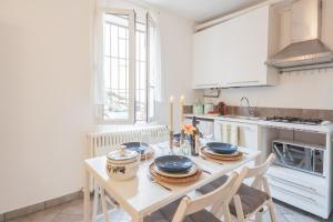 a kitchen with a table with plates on it at Up On the Roof by Rent All Como in Como