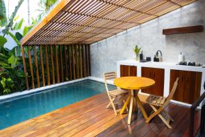 a patio with a table and chairs and a swimming pool at Manao Villas in General Luna
